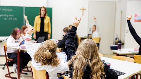 Schülerinnen einer sechsten Klasse melden sich in einem Klassenraum (Archivbild)