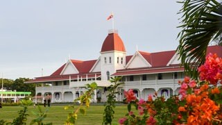 Der Königspalast des Königreichs Tonga in der Hauptstadt Nuku'alofa. Es ist ein Gebäude mit roten Dächern und einer weißen Fassade.