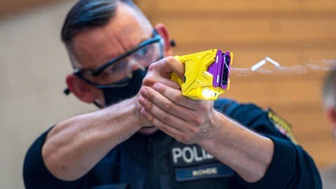 Ein Polizeihauptkommissar demonstriert den Einsatz des Distanz-Elektroimpulsgeräts (DEIG), eines sogenannten Tasers.