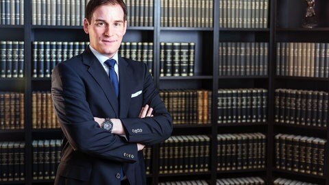 Strafrechts-Professor Florian Eder von der Polizeihochschule BW vor einer Bücherwand