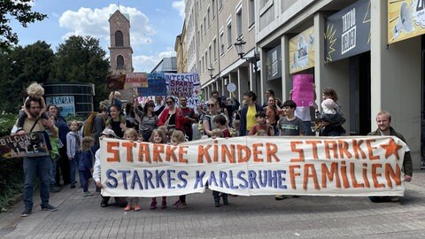Eltern demonstrieren mit ihren Kindern in der Innenstadt von Karlsruhe