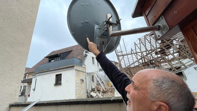 Ludwig Münch zeigt auf seine von Splittern durchlöcherte Sat-Antenne.