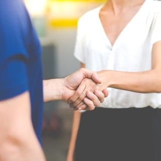 Mann und Frau schütteln sich die Hände