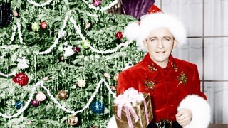 Wundervolles Weihnachtswissen: Was sind die größten Weihnachts-Hits aller Zeiten? Das Bild zeigt Bing Crosby im Weihnachtsmann-Kostüm vor einem Christbaum