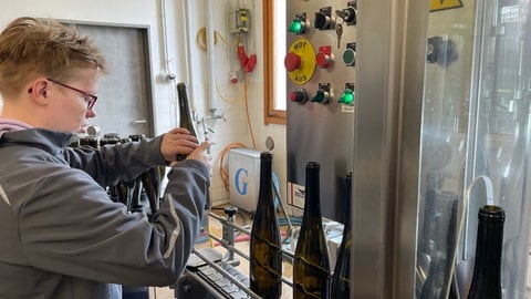 Alice vom Solzialwerk des DRK in Bernkastel-Kues füllt Weinflaschen ab, die in ganz Deutschland verkauft werden. 