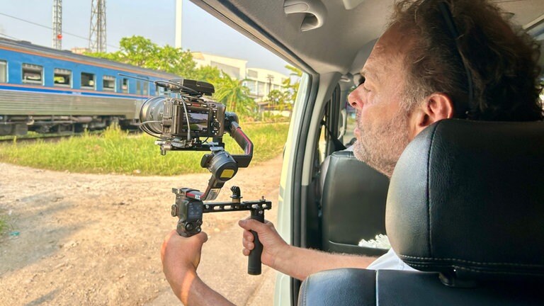 Wenn kein Kanal zu den Gleisen parallel verläuft, dann ist es eine Straße: eine gute Gelegenheit, den langsam fahrenden Zug aus dem Auto heraus zu filmen. 