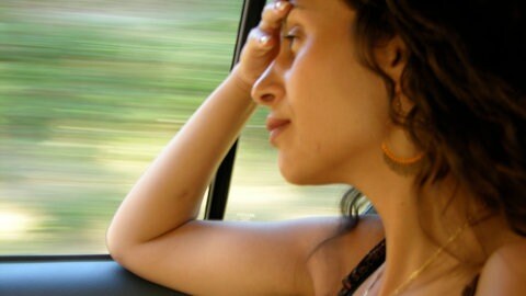 Frau schaut aus Autofenster. Reiseübelkeit entsteht vor allem durch widersprüchliche Informationen von verschiedenen Sinnesorganen. Musik kann die Reiseübelkeit bestenfalls sogar verringern. (Symbolfoto)