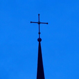 Evangelisches Kreuz vor blauem Himmel 