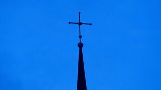 Evangelisches Kreuz vor blauem Himmel 