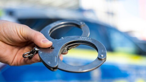Symbolbild von Handschellen: Eine junge Frau sitzt in U-Haft, weil sie die Getränke von Kollegen mit Medikamenten versetzt haben soll.