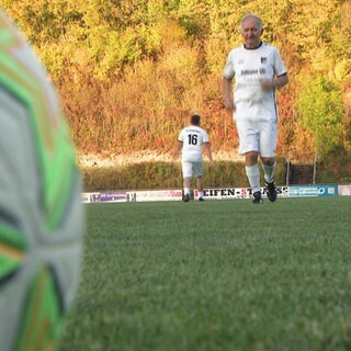 Ein 72-jähriger Mann läuft in Fußballklamotten auf einen Fußball zu.