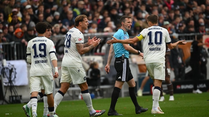 Marcel Franke und Marvin Wanitzek (re.) vom Karlsruher SC diskutieren mit Schiedsrichter Lukas Benen nach dem aberkannten Treffer durch Christoph Kobald.