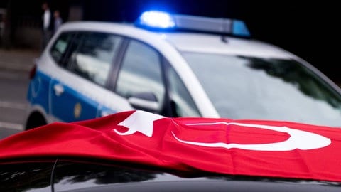 Polizeiauto hinter einem Auto mit Türkei-Flagge: Zweit Hochzeitkorsos haben am Sonntag den Verkehr auf der A60 bei Mainz ausgebremst. 