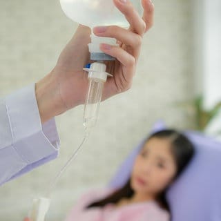 Eine Ärztin bereitet eine Infusion für eine Patientin vor: Das deutsche Gesundheitssystem geht vom weißen männlichen Körper als Norm aus. Mit gefährlichen Folgen