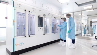 Zwei Beschäftigte im ehemaligen CureVac-Unternehmen stehen vor dem mRNA-Reprinter in Tübingen. Nun bangen sie um ihre Zukunft, nachdem BioNTech die Schließung angekündigt hat.