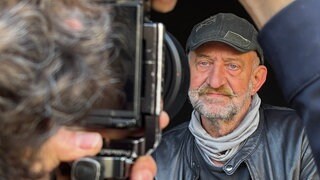 Ein Mann wird von einem professionellen Fotografen abgelichtet.