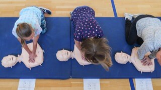 Drei Kinder üben Erste Hilfe an Puppen (Symbolbild) | Vier Jahre nach der Ahrtalflut: Wie ein DRK-Projekt Kindern nach der Flut im Ahrtal hilft