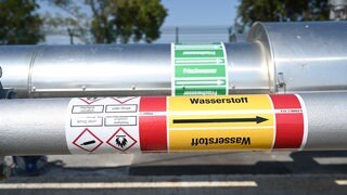 Ein Rohr mit der Aufschrift "Wasserstoff" führt aus einer unterirdischen Speicheranlage nach oben.