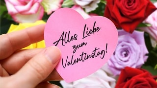 Rosen und ein Zettel mit der Aufschrift "Alles liebe zum Valentinstag".