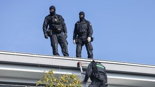 Polizisten durchsuchen den Balkon eines Wohnhauses. Bei einem europaweiten Einsatz gegen die organisierte Drogenkriminalität durchsuchten Einsatzkräfte am Donnerstag europaweit Wohn- und Gewerbeobjekte - auch in Rheinland-Pfalz.