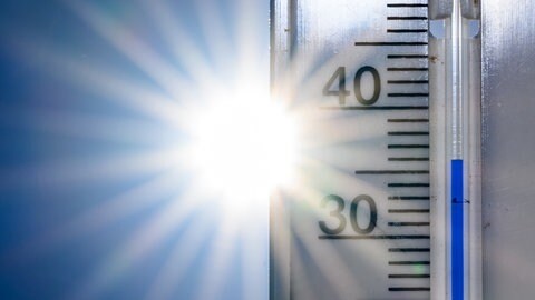 36 Grad Celsius zeigt ein Thermometer vor der Nachmittagssonne an (Symbolbild). Die Stadt Landau will insbesondere ihre Grundschulen und Kitas mit Geld aus dem Sondervermögen besser vor Hitze schützen.