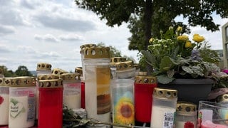 Ein Student ist in Trier auf offener Straße erstochen worden. Am Tatort haben Menschen Kerzen und Blumen niedergelegt.