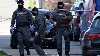 Beamte des Entschärfungsdienstes der Polizei sind an einem beschädigten Fahrzeug an einer Zufahrt zur Rheinbrücke im Einsatz. Nach einem Vorfall mit einem Auto in der Mannheimer Innenstadt mit mindestens einem Toten und mehreren Verletzten ist der mutmaßliche Fahrer nach Polizeiangaben festgenommen worden.