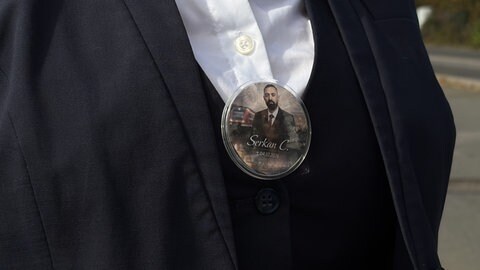 Eine frühere Kollegin von Serkan Çalar trägt sein Foto jeden Tag an ihrer Arbeitskleidung.