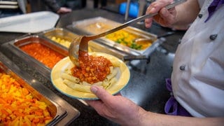 Ein Koch serviert in einer Mensa ein veganes Gericht mit Nudeln und Soja-Bolognese. Laut einer Studie der Uni Konstanz boomt veganes Essen in Hochschulmensen.