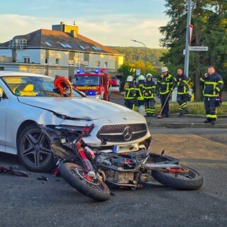Ein zerstörtes Motorrad liegt unter einem Auto: Bei einem Unfall in Bad Sobernheim sind ein junger Motorradfahrer und sein Beifahrerin schwer verletzt worden. 