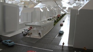 Ein Modell der Turmbergbahn: Talstation mit weißen Häußern und bunten Autos auf den Straßen.