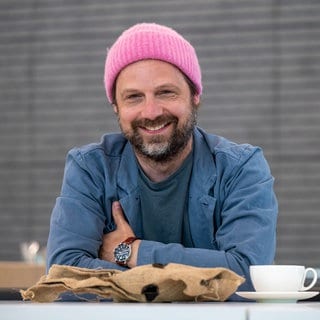 Der Schauspieler und Musiker Christoph Letkowski lacht in die Kamera.
