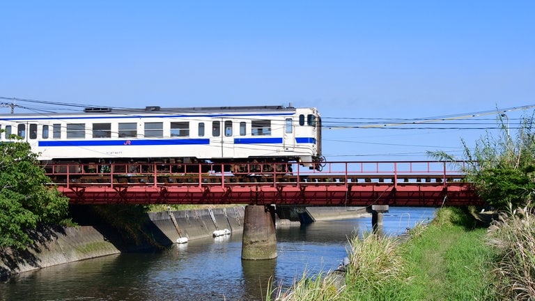 Unterwegs nach Ibusuki - ein Nahverkehrszug passiert eine der vielen kleinen Brücken. Typisch für Japan, die Brücke hat keinen seitlichen Weg und kein Geländer.