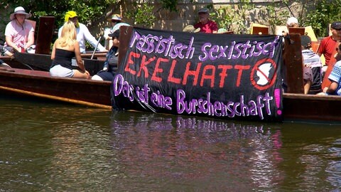 Der feministische "Flinta-Kahn" protestiert mit Bannern auf dem Neckar gegen das Stocherkahnrennen. 