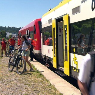 Die Biberbahn fährt zwischen Stockach und Mengen. Eine Familie mit Fahrrädern steigt in den Zug.