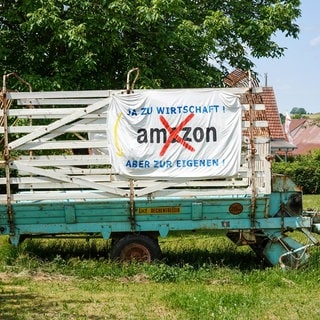 Ein Plakat an einem Anhänger, das sich gegen das geplante Amazon-Verteilzentrum bei Bad Urach richtet.