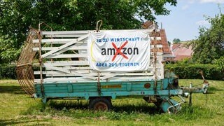 Ein Plakat an einem Anhänger, das sich gegen das geplante Amazon-Verteilzentrum bei Bad Urach richtet.