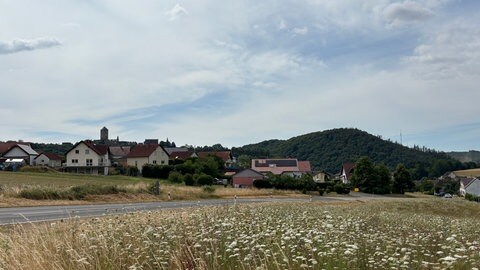 Der Ortseingang von Thallichtenberg im Landkreis Kusel im Juli im Sommer bei bewölktem Himmel.
