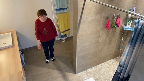 Gudrun Fritz steht in ihrem Badezimmer in Forbach und deutet auf den braunen Fliesenboden. Ihr Mann lag hier, als sie lange auf den Rettungswagen warteteten.