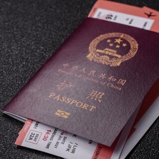 Symbolbild: Chinesischer Reisepass mit Tickets als Hintergrund 