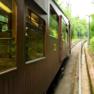 Die Stuttgarter Seilbahn fährt durch einen Wald den Berg zum Waldfriedhof hinauf.