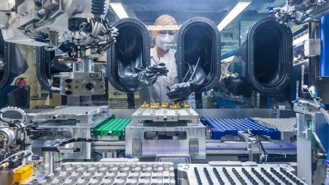 Im MEET Batterieforschungszentrum arbeitet eine Doktorandin im Reinraumlabor an der Weiterentwicklung elektrochemischer Energiespeicher, hier Lithium-Ionen-Akkumulatoren. 