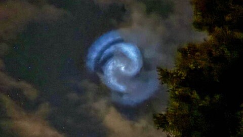 Weiß-bläulich schimmert eine Lichtspirale am Nachthimmel.