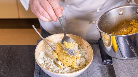 Aufstrich zubereiten: Die gekochte Hirse und das zerkleinerte Gemüse wird mit Frischkäse vermischt.