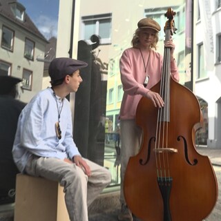 Zwei 13-jährige Jungen spielen Musik in der Fußgängerzone