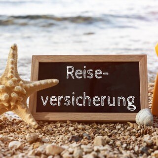Schild mit Reiseversicherung - Schutz im Urlaub und Ausland
