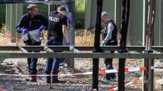 Polizisten stehen auf dem Gelände des Umspannwerks, das durch Brandstiftung ausgefallen ist.