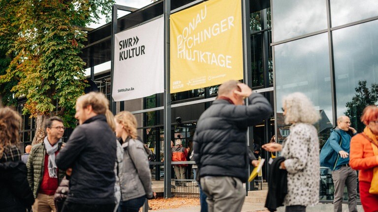 Publikum der Donaueschinger Musiktage vor den Donauhallen