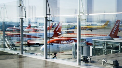 Maschinen der britischen Fluggesellschaft Easyjet stehen am Flughafen EuroAirport. Zu sehen sind ebenfalls Frachtmaschinen von DHL.
