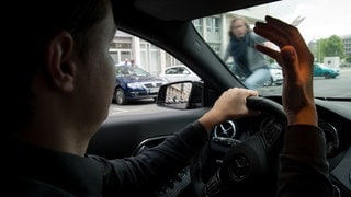Ein Autofahrer und eine Radfahrerin streiten sich (Symbolbild). Das sagt eine Verkehrspsychologin zu Konflikten im Straßenverkehr.